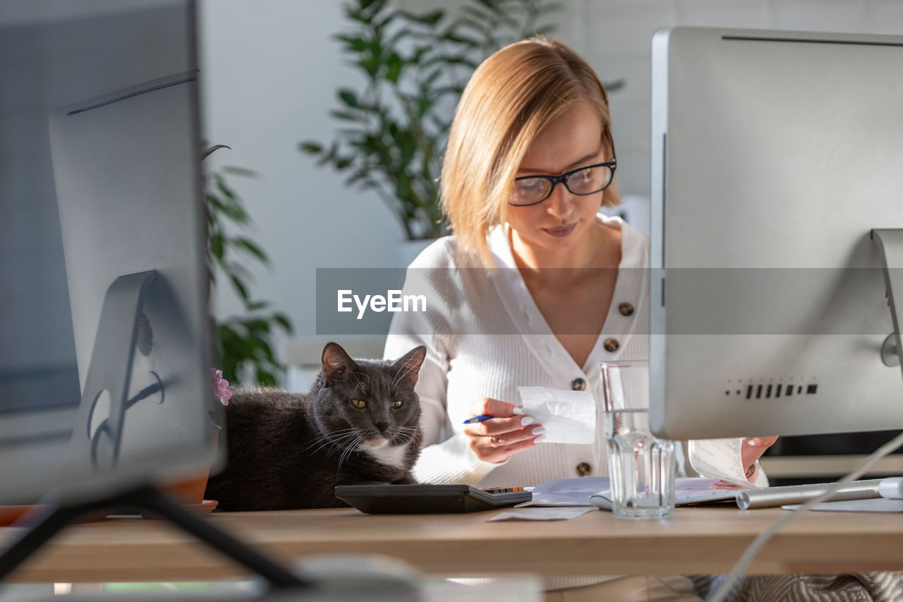 Businesswoman with cat on desk working in office