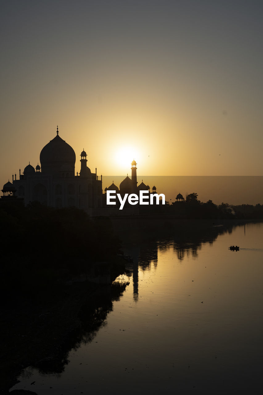 Taj mahal reflected in yamuna river at sunset in agra, india. 