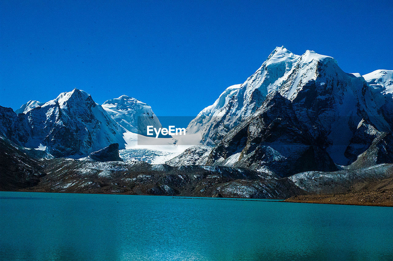 SNOWCAPPED MOUNTAINS AGAINST BLUE SKY