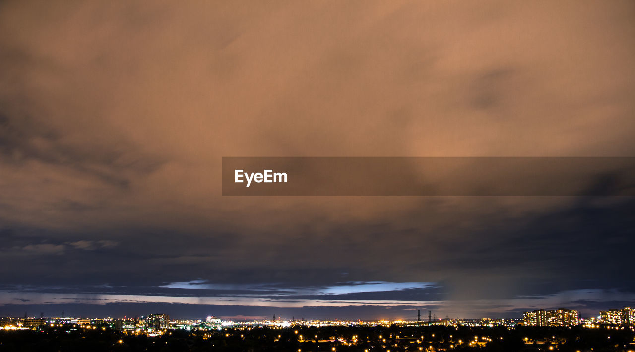 Illuminated cityscape against sky at night