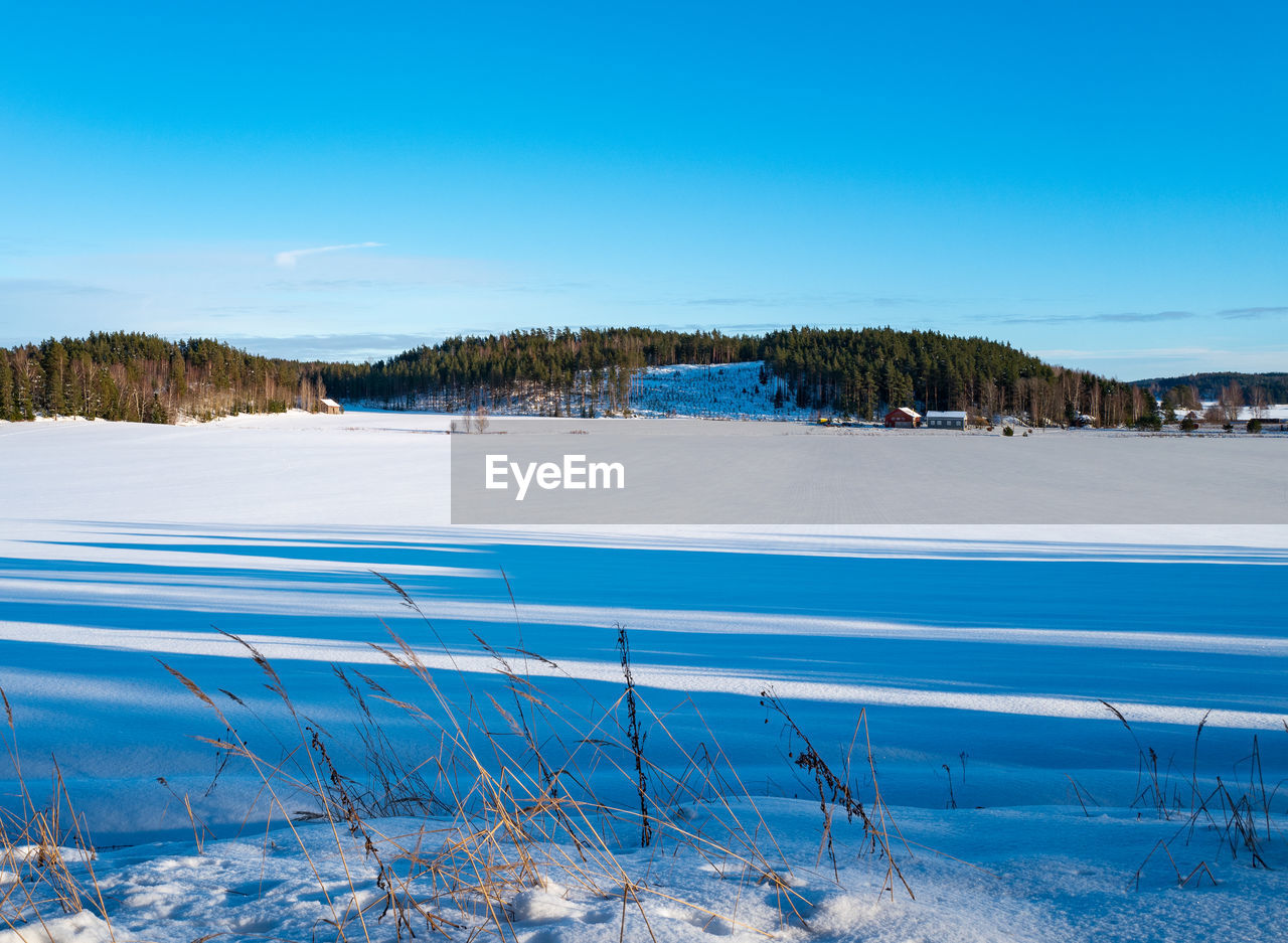 Scenic view of snowcapped landscape against blue sky