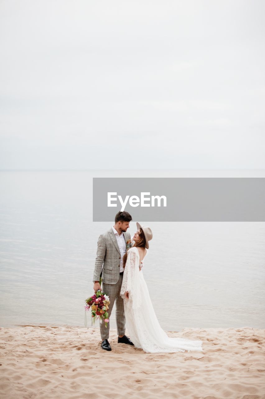 Bride and bridegroom standing at beach during wedding ceremony