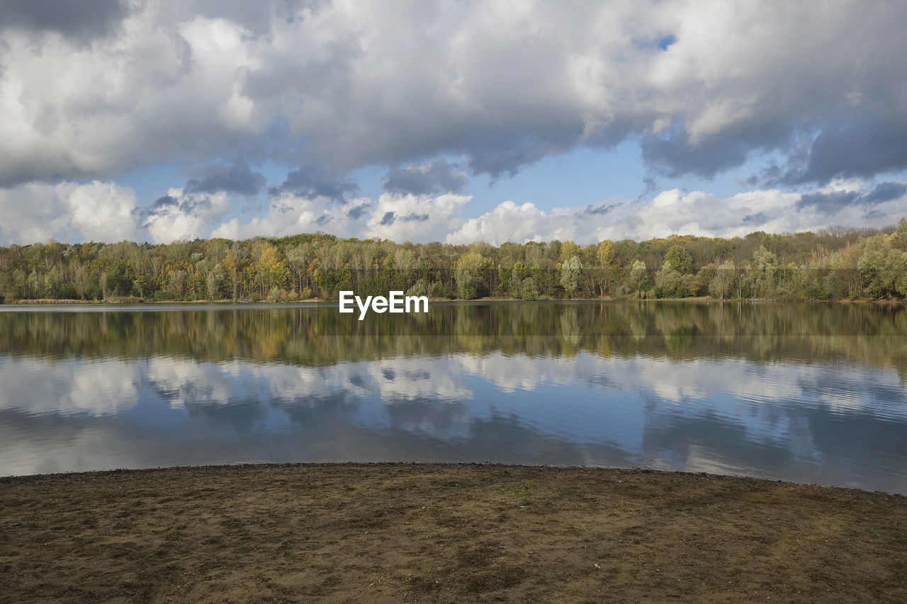 A lake in which the white clouds are reflected and its shore.