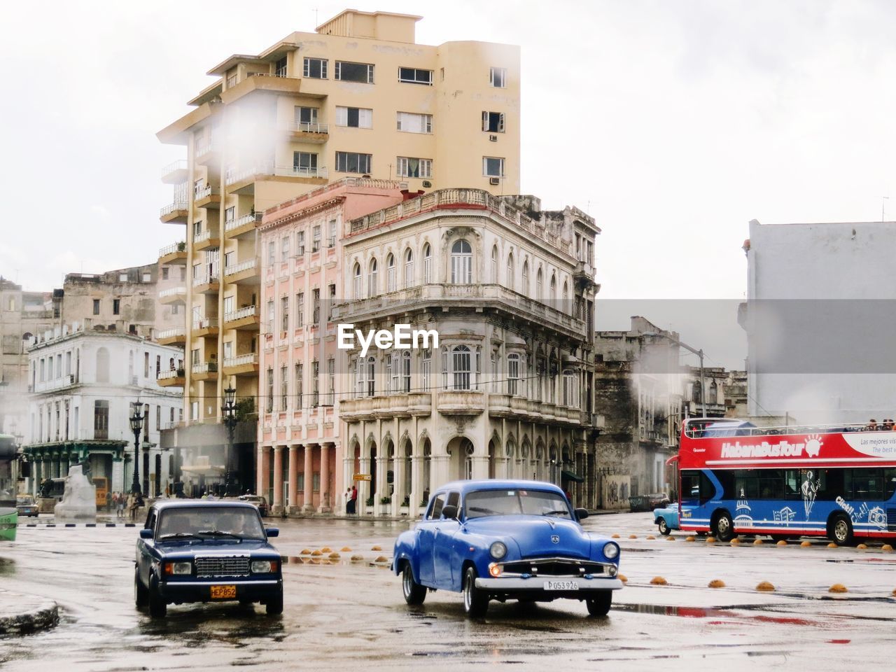 Cars on road in city against sky