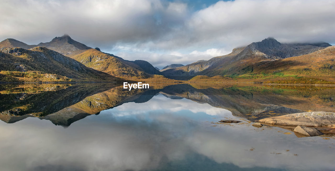 Beautiful mountainous landscape reflected on the water with clouds in the sky - svolvaer in norway