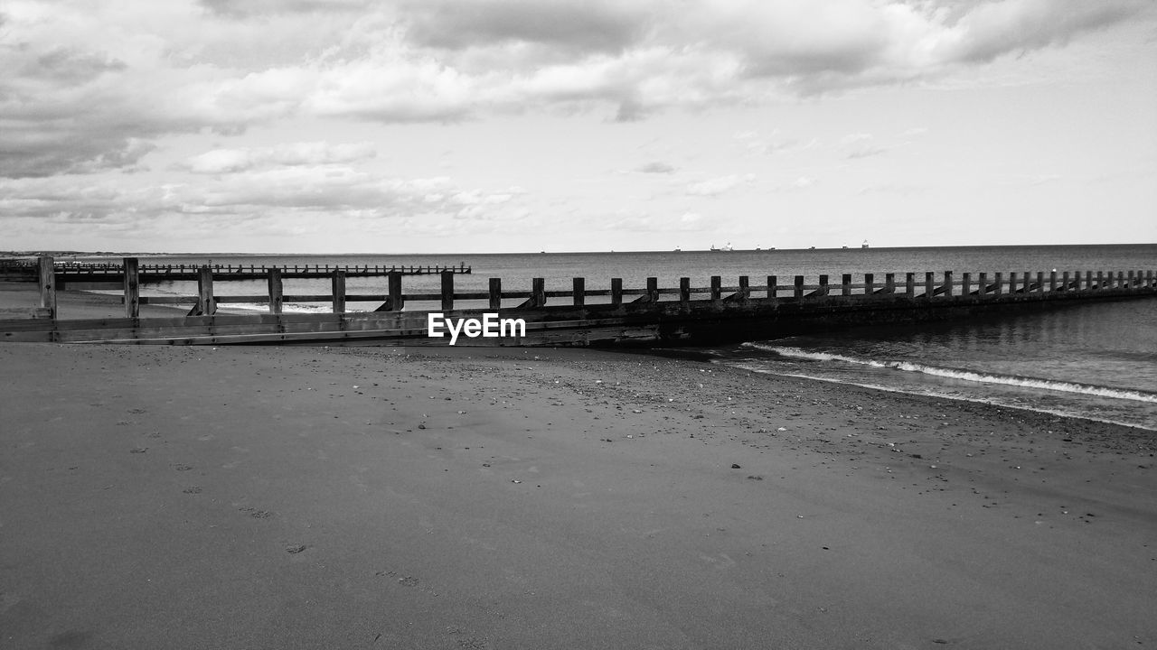 Jetty at calm sea against the sky