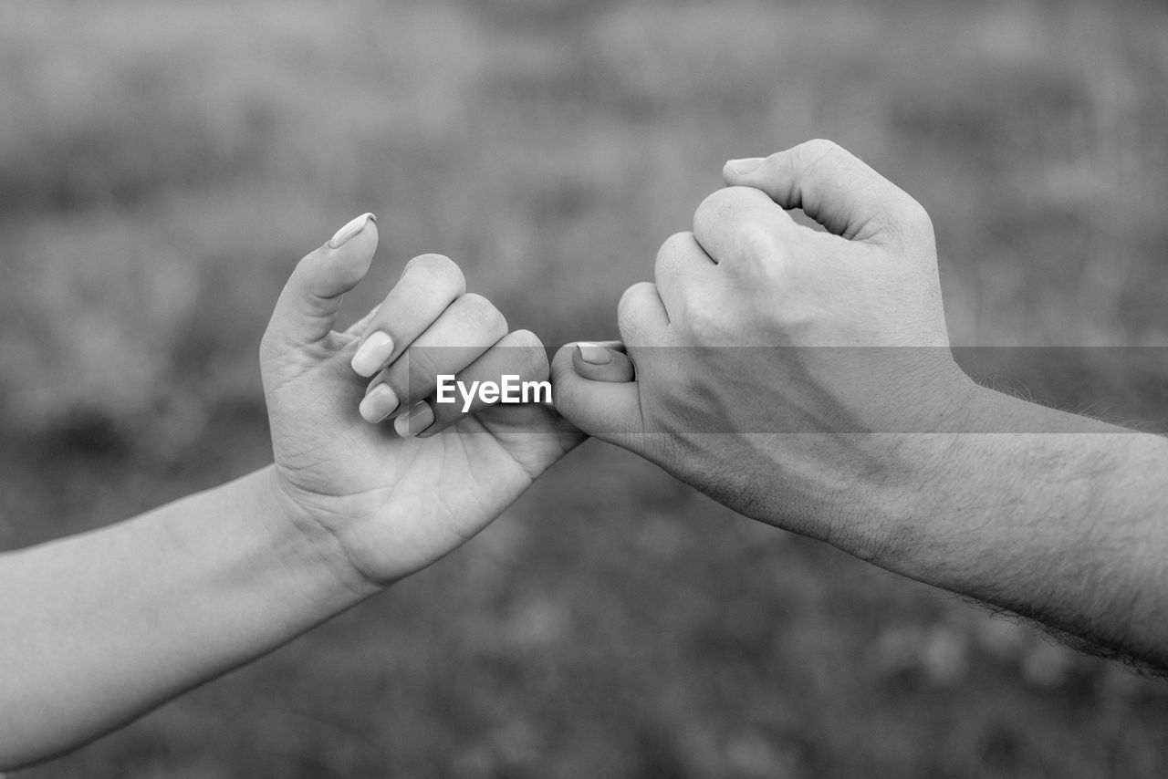 Close-up of people holding little finger