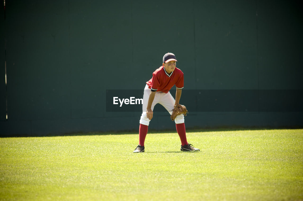 Boy in ready position in the outfield of a baseball field