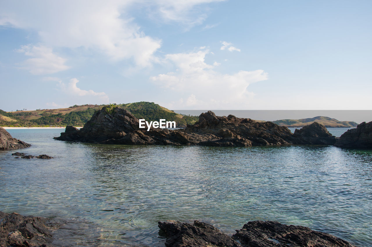 Scenic view of rocks in sea against sky