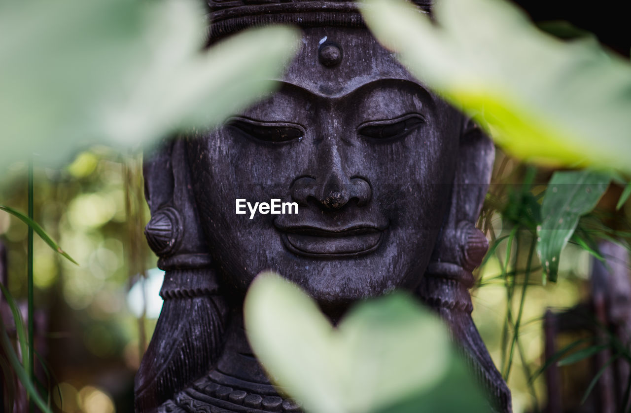 CLOSE-UP OF STATUE OF BUDDHA