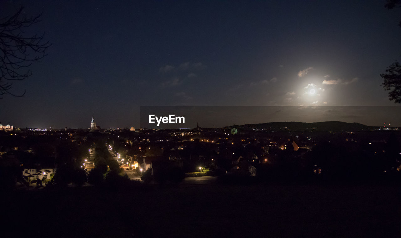 ILLUMINATED CITYSCAPE AGAINST SKY