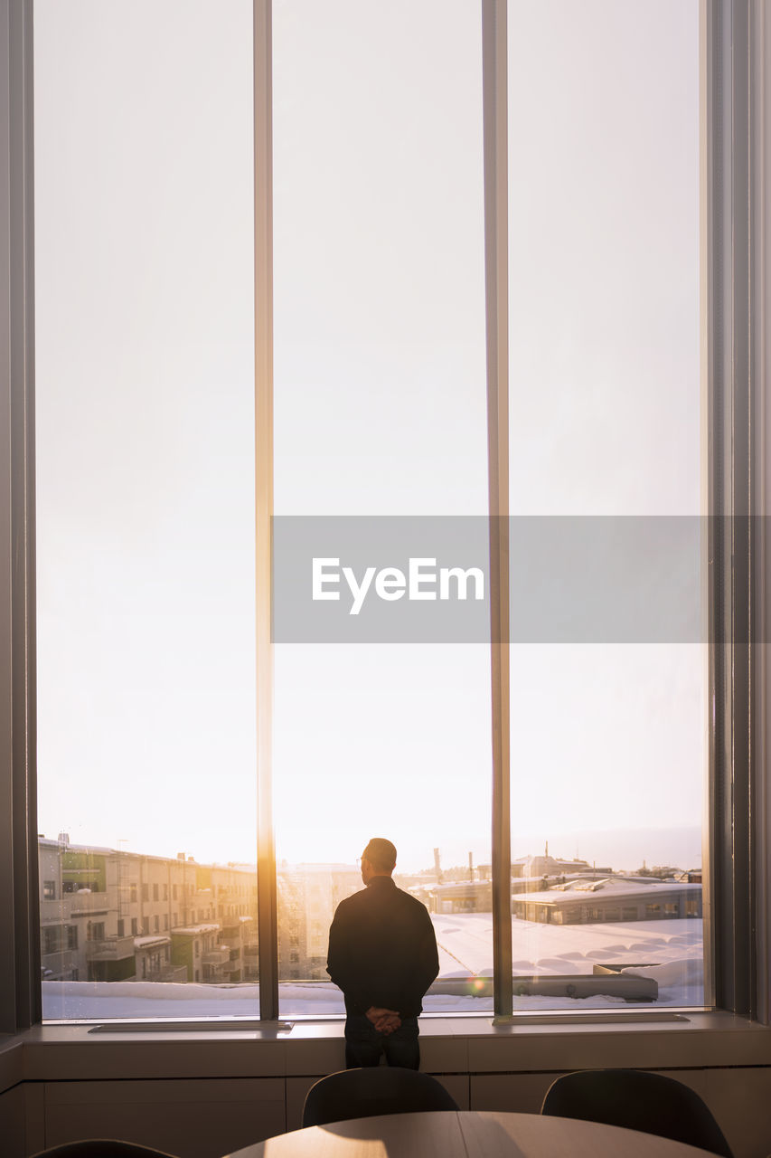 Businessman looking through office window