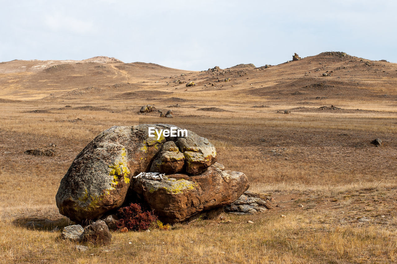 ROCKS ON LAND AGAINST SKY