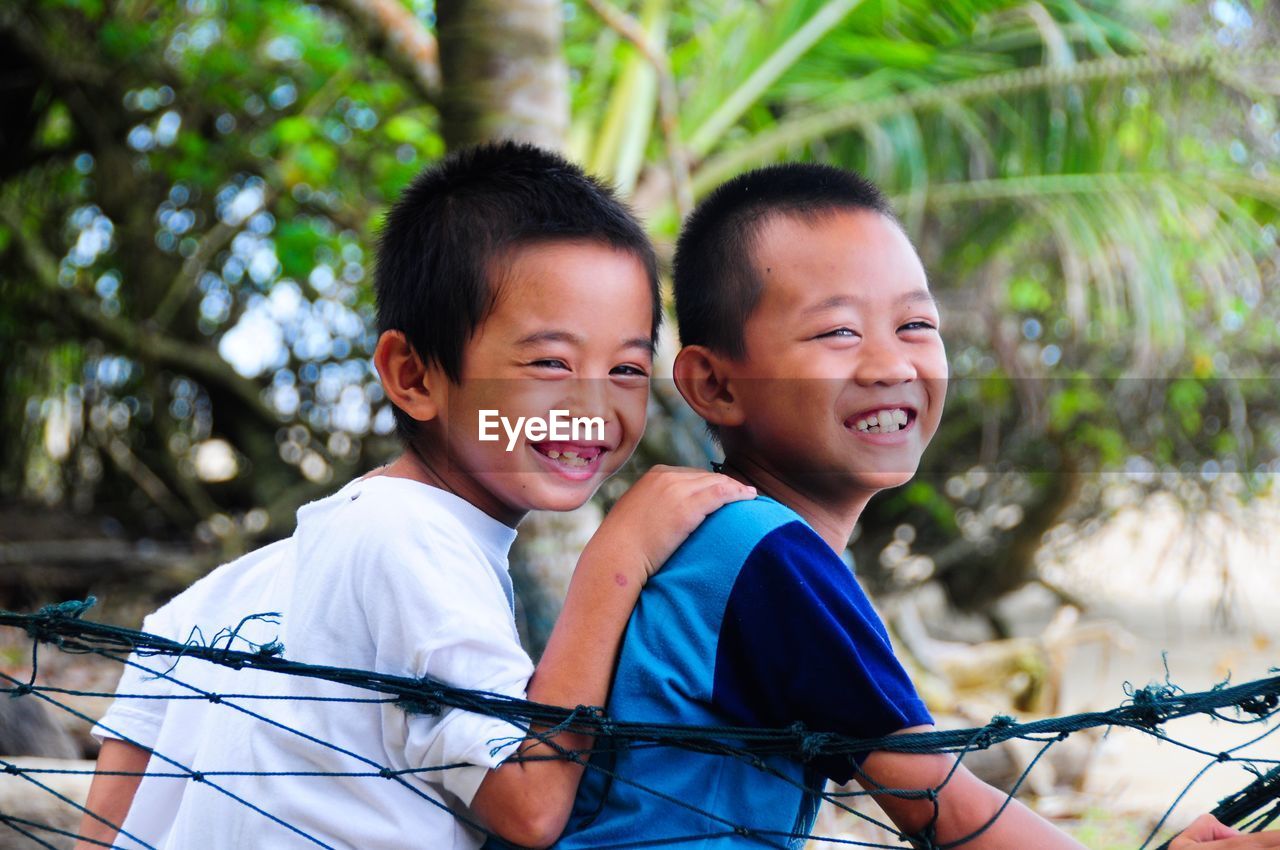 PORTRAIT OF SMILING BOY AND DAUGHTER OUTDOORS