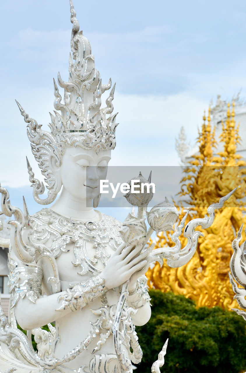 SCULPTURE OF BUDDHA AGAINST SKY