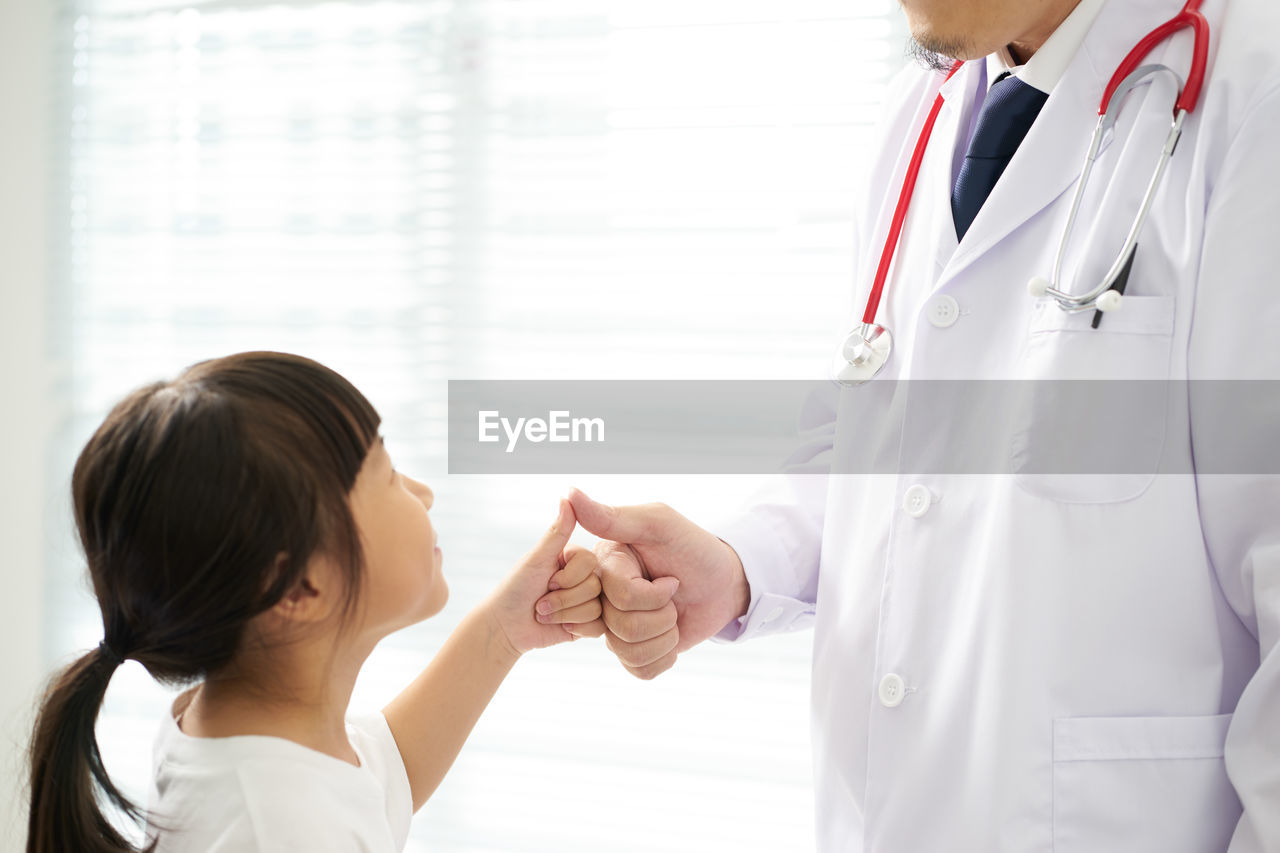 Doctor and girl gesturing thumbs up