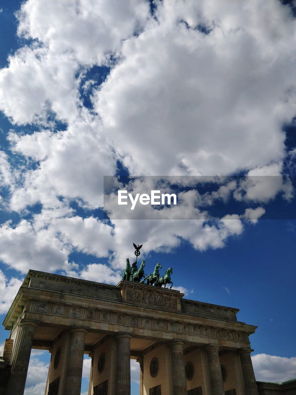 Low angle view of brandenburg gate against cloudy sky