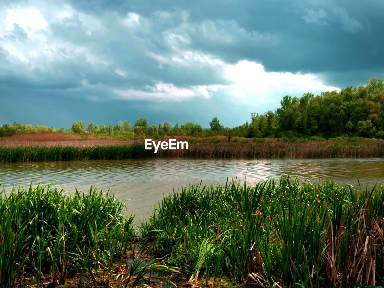 SCENIC VIEW OF CALM LAKE AGAINST SKY