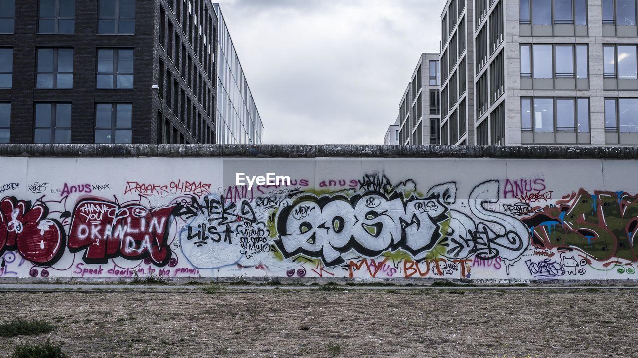 GRAFFITI ON WALL AGAINST BUILDING IN CITY