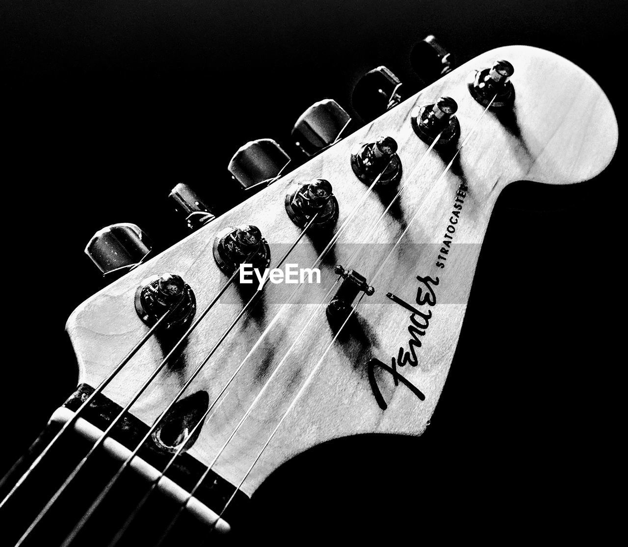 HIGH ANGLE VIEW OF GUITAR PLAYING WITH BLACK BACKGROUND