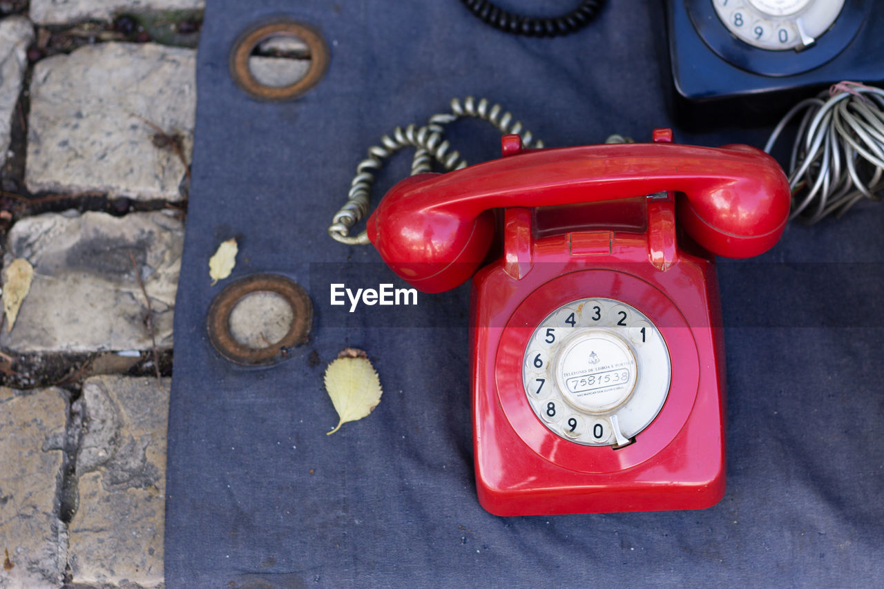 High angle view of old-fashioned telephones on textile