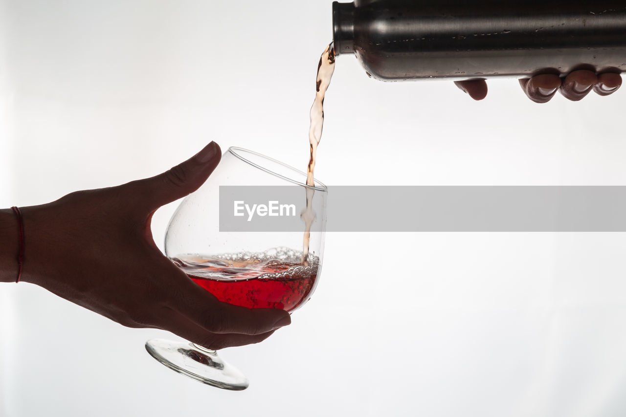 CLOSE-UP OF HAND HOLDING GLASS OF WATER