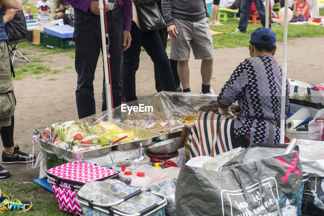 Vendor selling food to customers at market