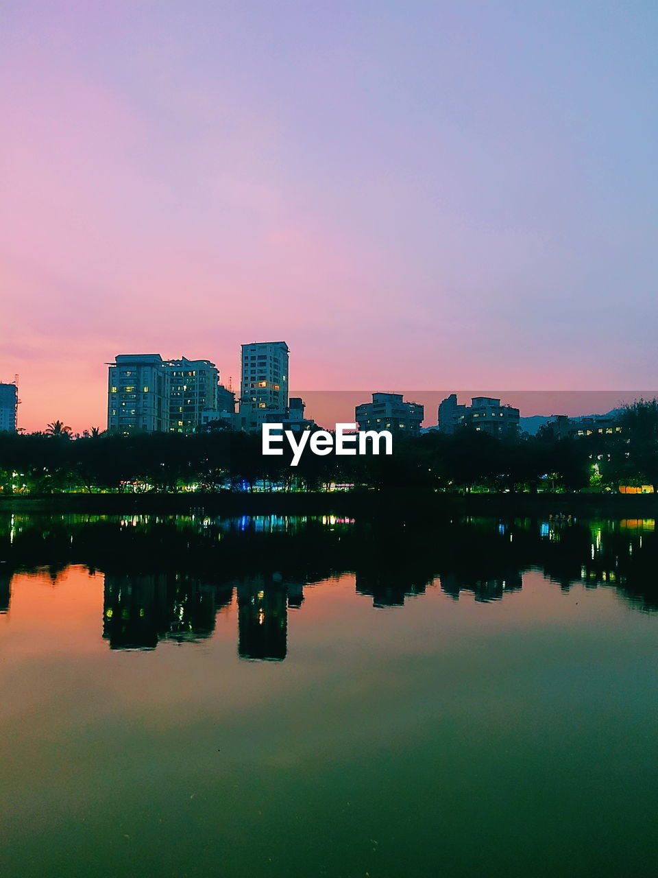 Reflection of buildings in lake at night