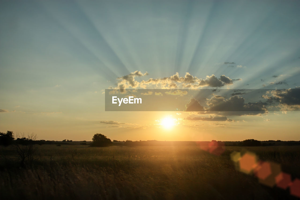 SCENIC VIEW OF SUNSET OVER FIELD