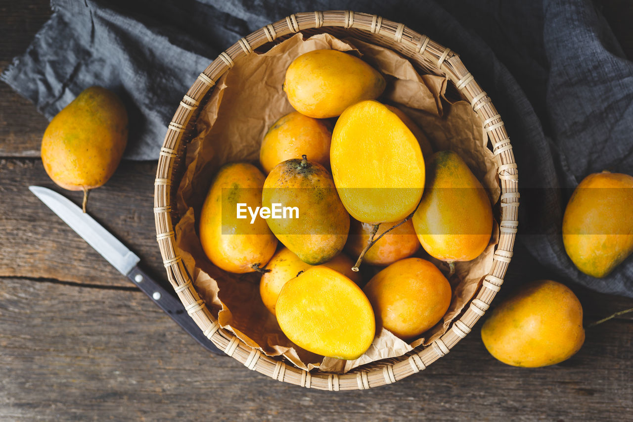 High angle view of mangoes in bowl on wooden table