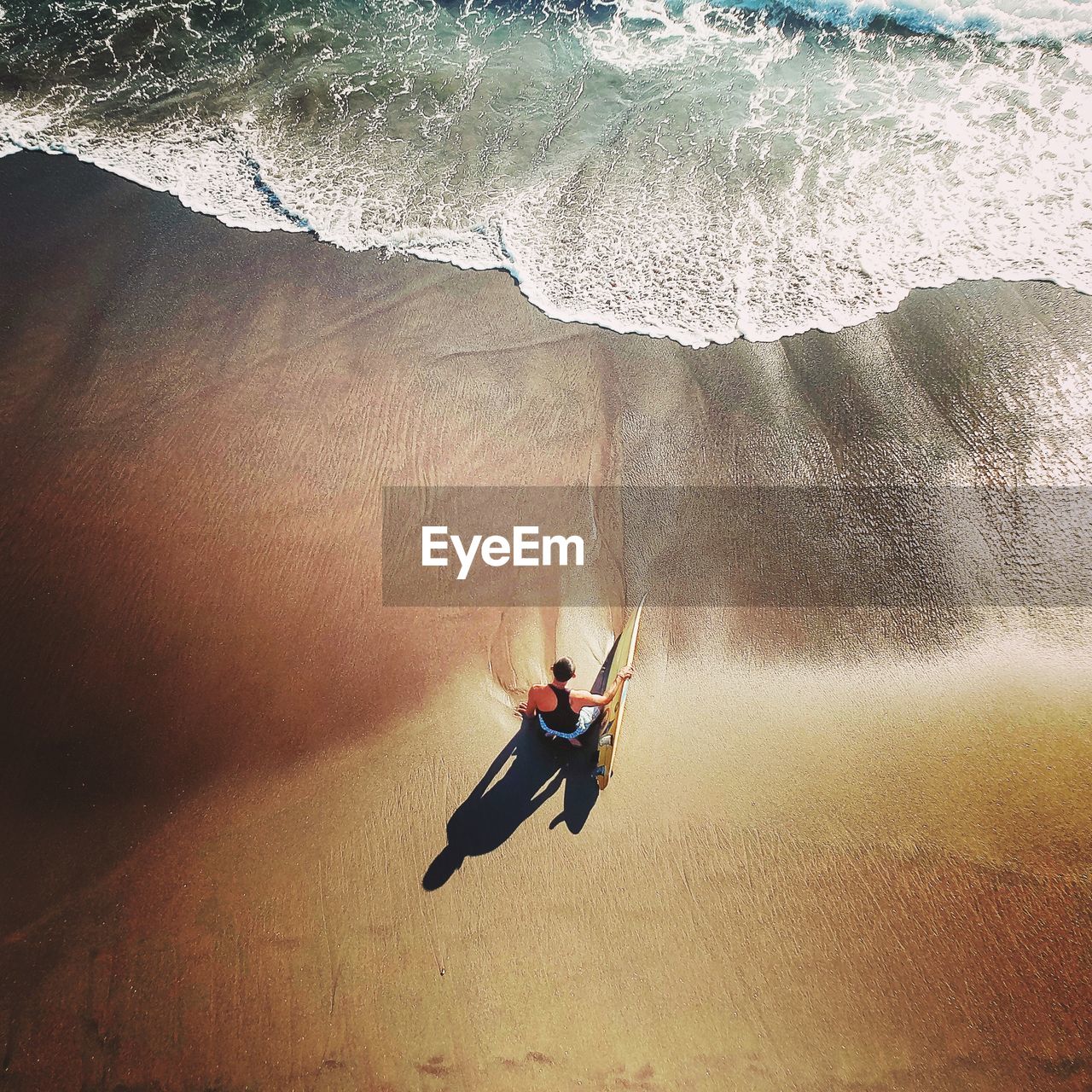 High angle view of man with surfing board on beach