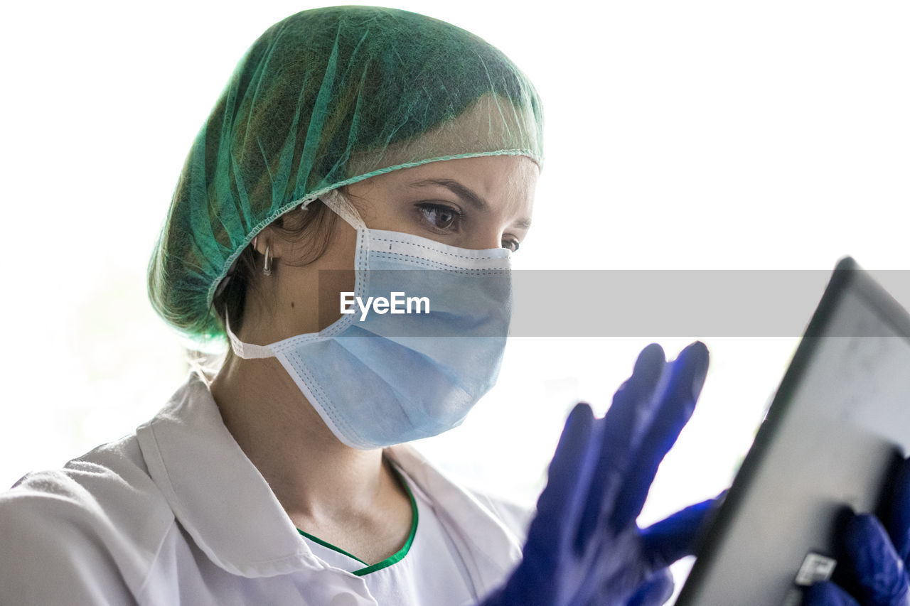Cropped shot of an unrecognizable female nurse using a digital tablet while standing in a hospitacropped shot of an unrecognizable female nurse using a digital tablet