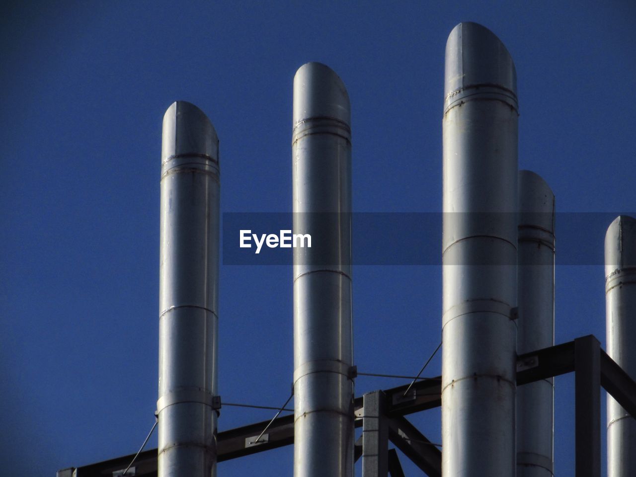 LOW ANGLE VIEW OF INDUSTRY AGAINST BLUE SKY