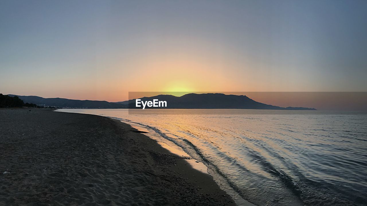 SCENIC VIEW OF BEACH DURING SUNSET