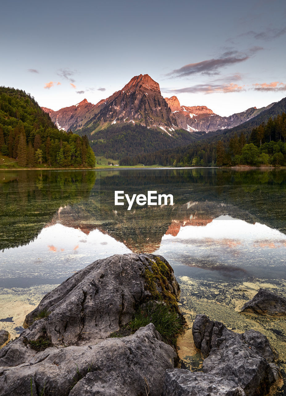 Scenic view of lake by mountains against sky