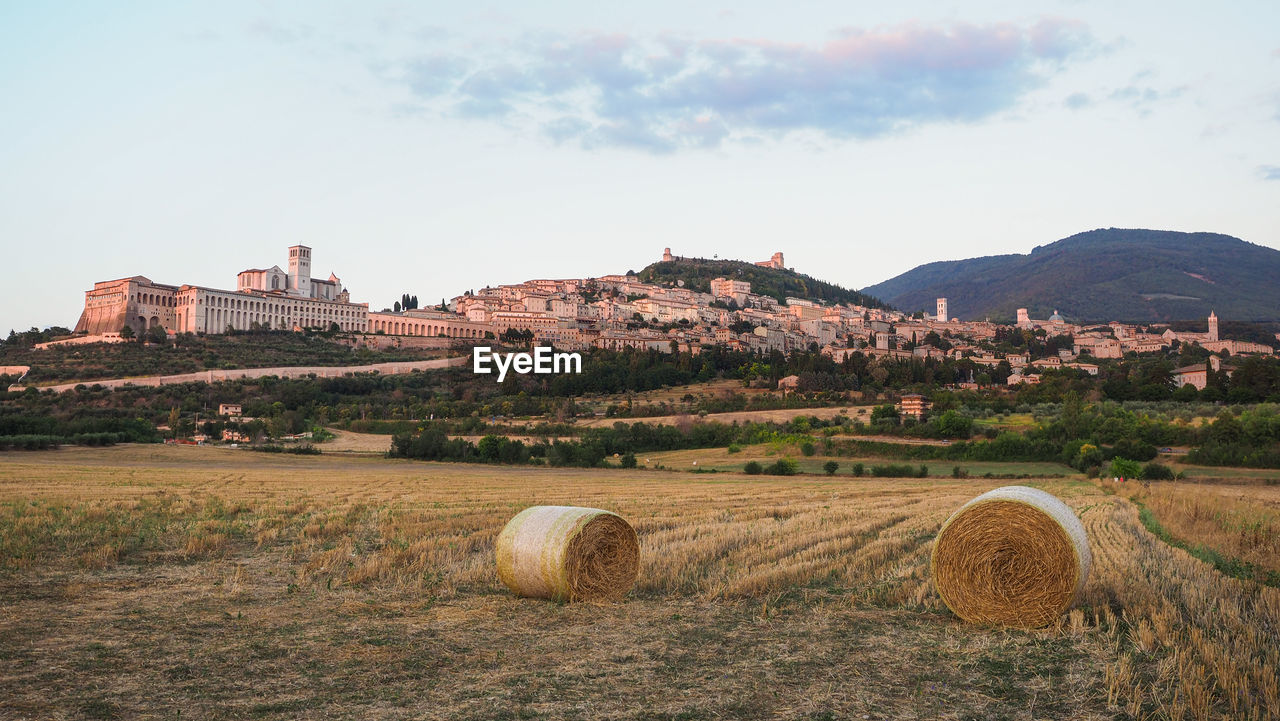 Hay bales on field against sky