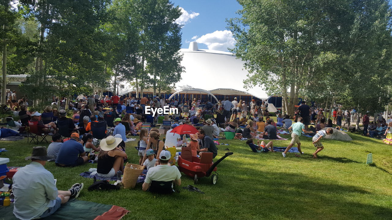 PEOPLE SITTING ON GRASS