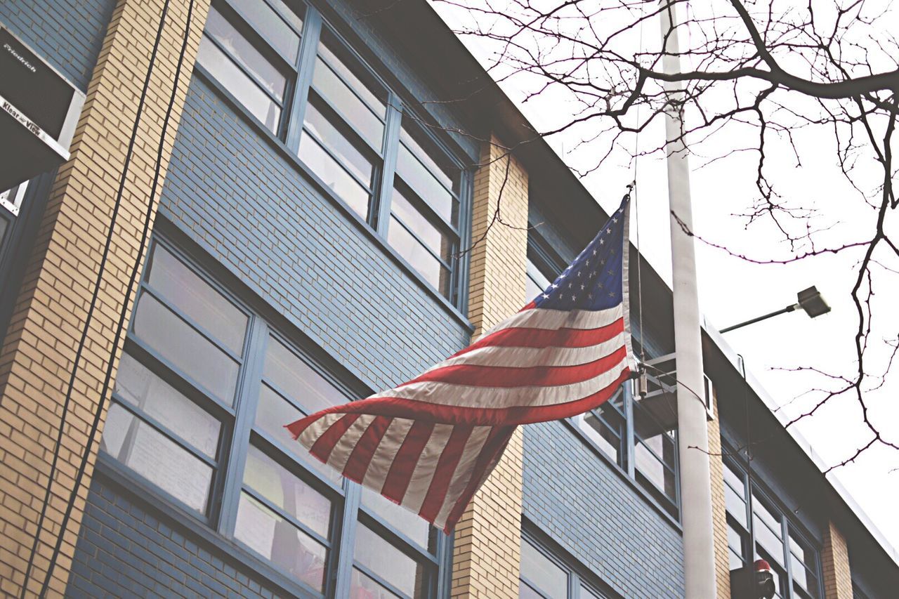 Low angle view of american flag against built structure