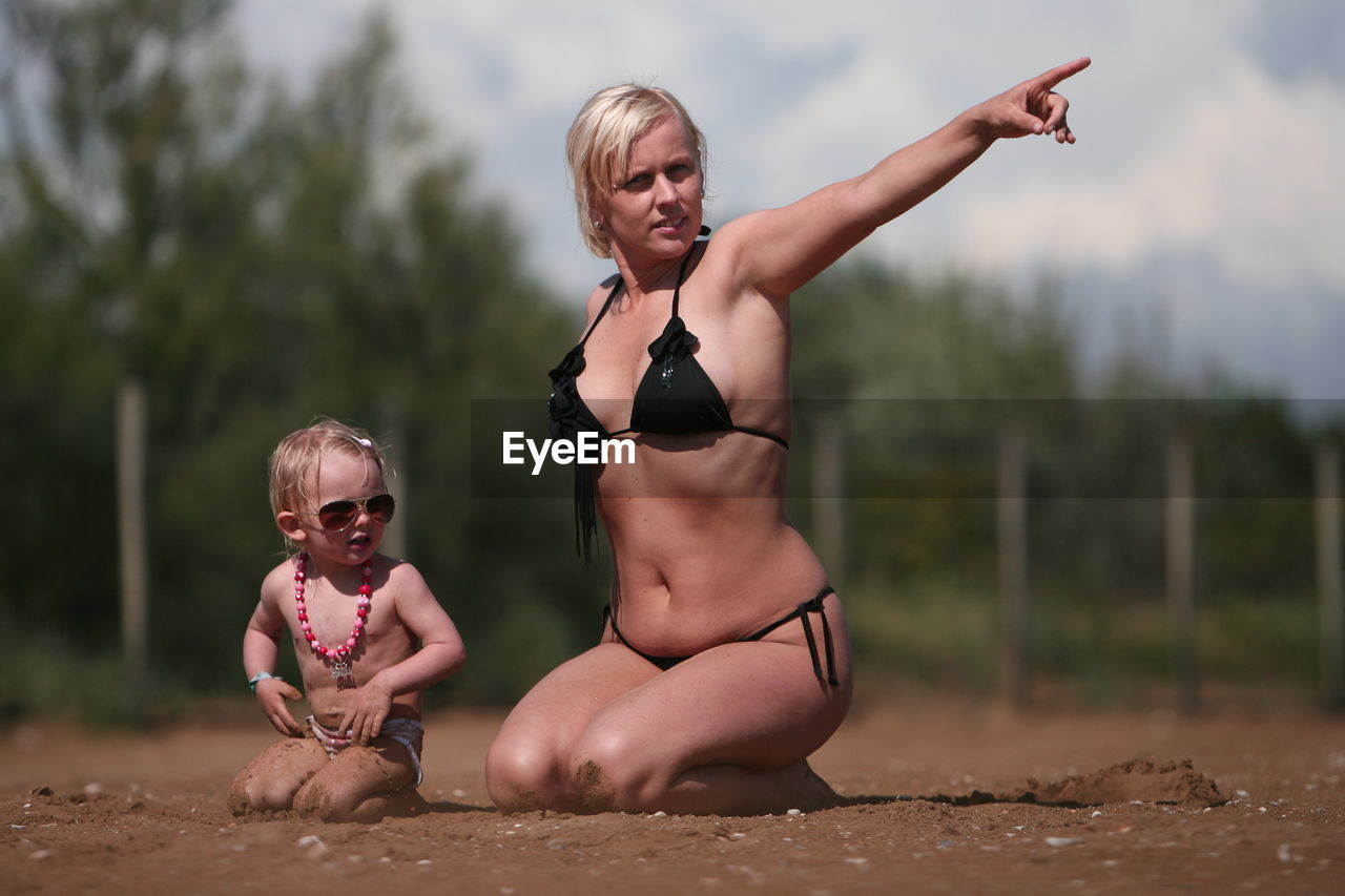 PORTRAIT OF YOUNG WOMAN IN SUNGLASSES AT BEACH