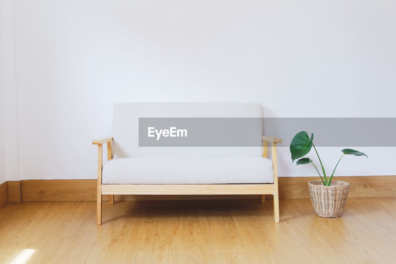 POTTED PLANT ON TABLE AGAINST WHITE WALL AT HOME