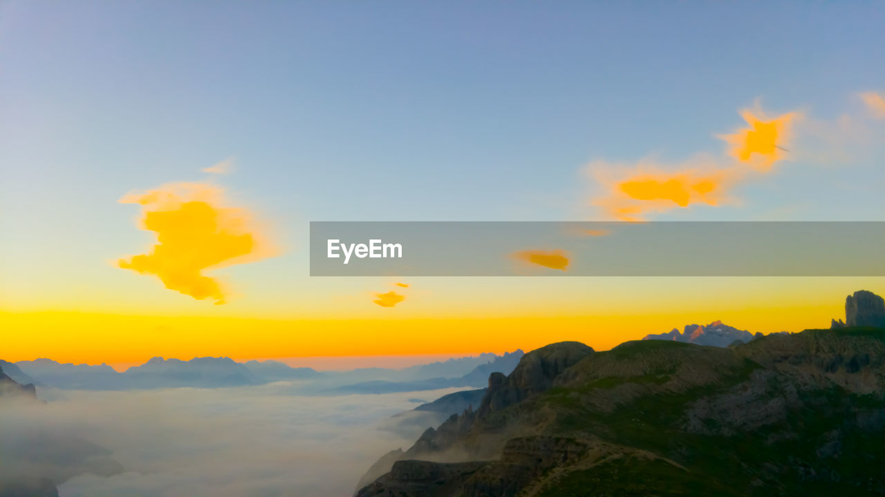SCENIC VIEW OF MOUNTAIN AGAINST SKY DURING SUNSET