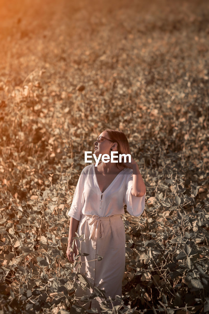 WOMAN LOOKING AWAY ON FIELD