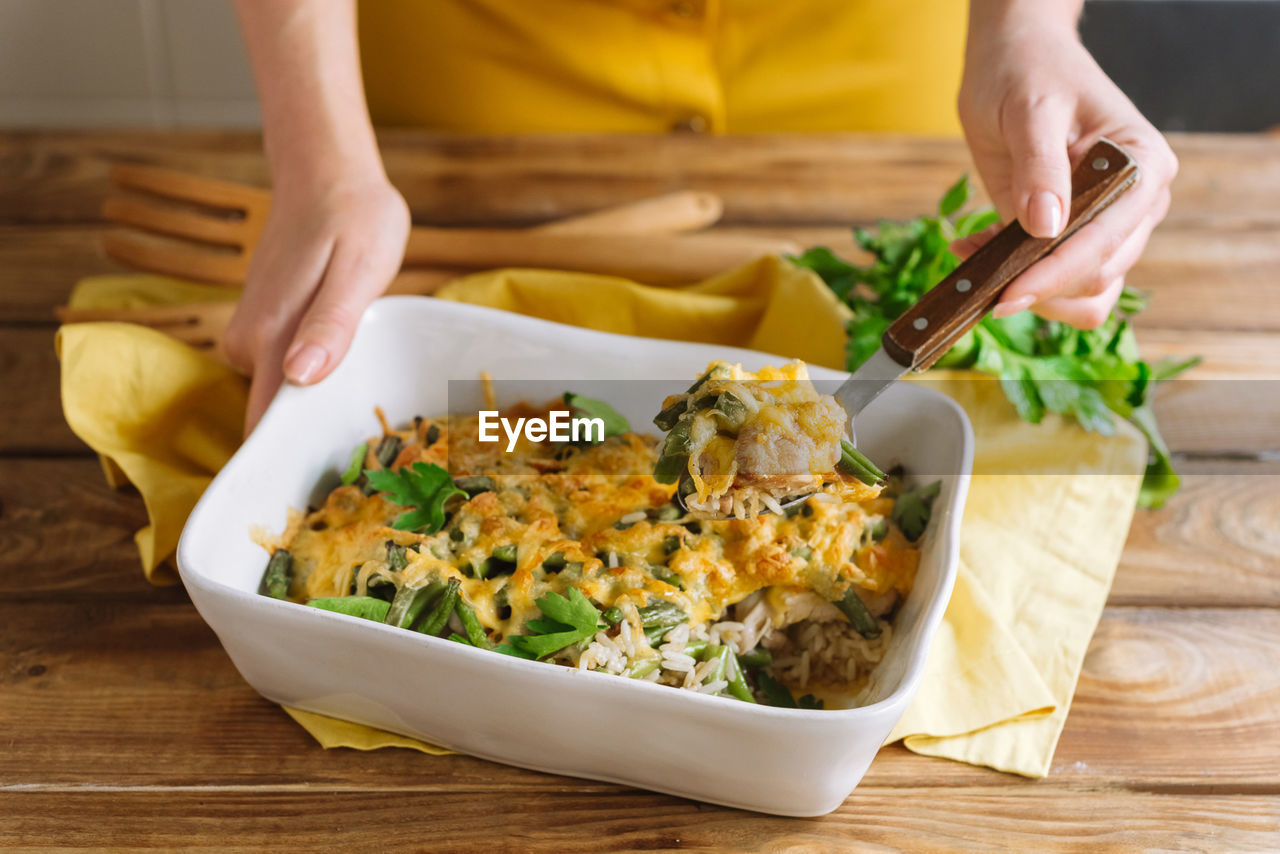 Fillet of chicken thigh with rice, cheese and soy sauce in a ceramic baking dish in the oven