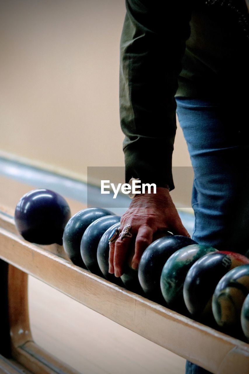 Midsection of man holding bowling ball