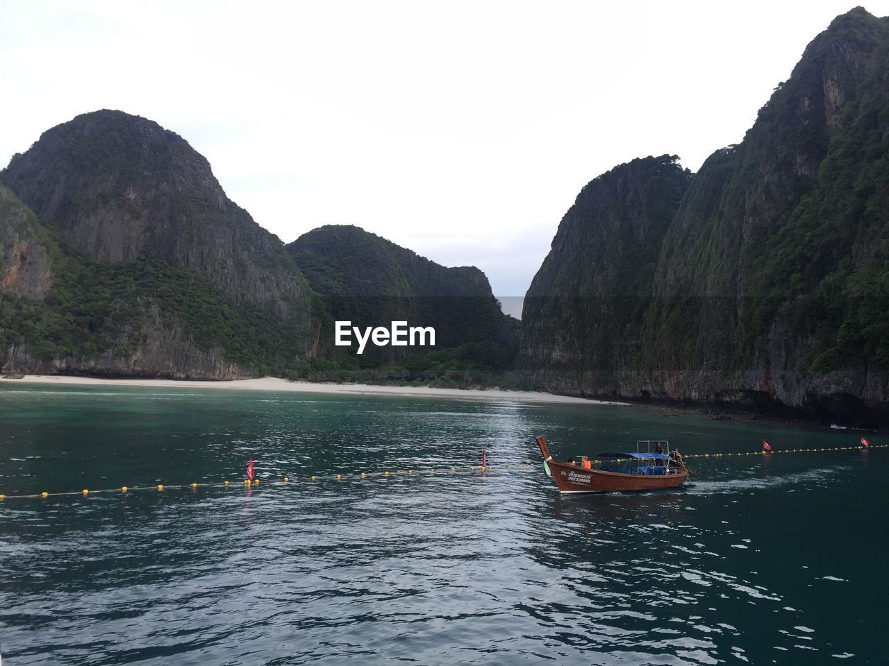 SCENIC VIEW OF SEA AGAINST MOUNTAINS