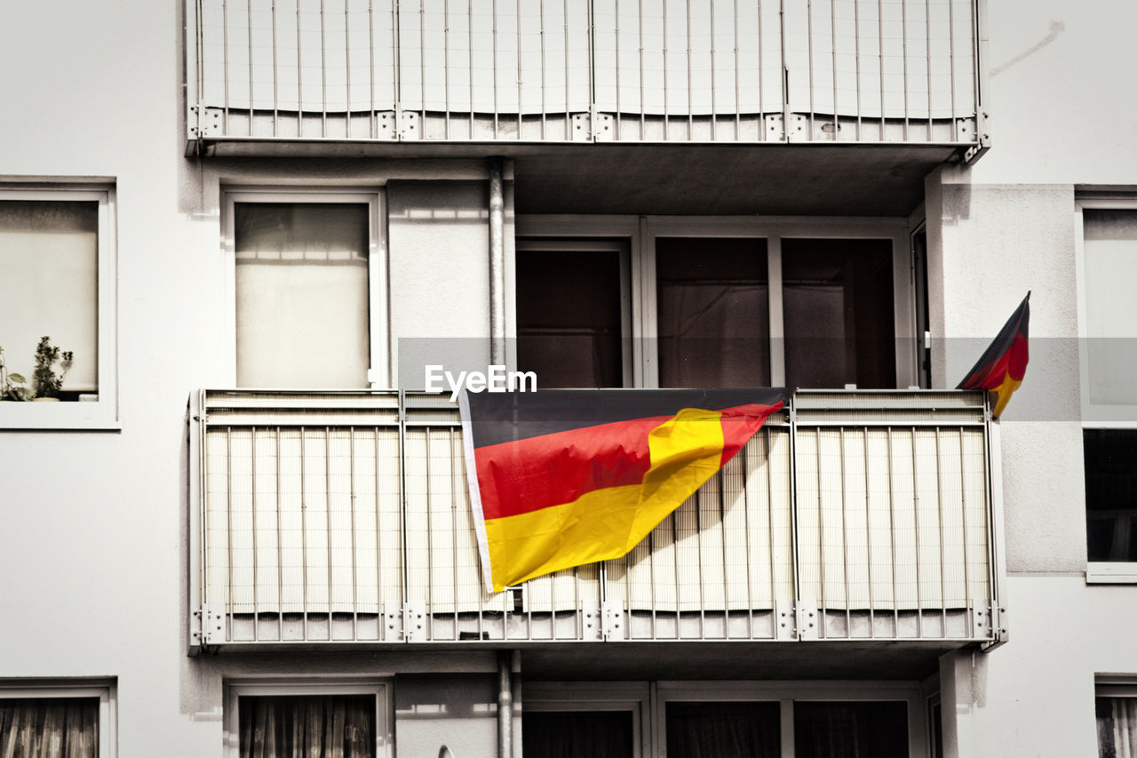 Multi colored flags hanging on balcony of building