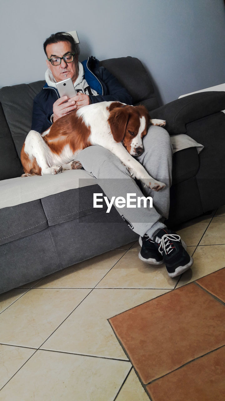 Man with dog on sofa at home