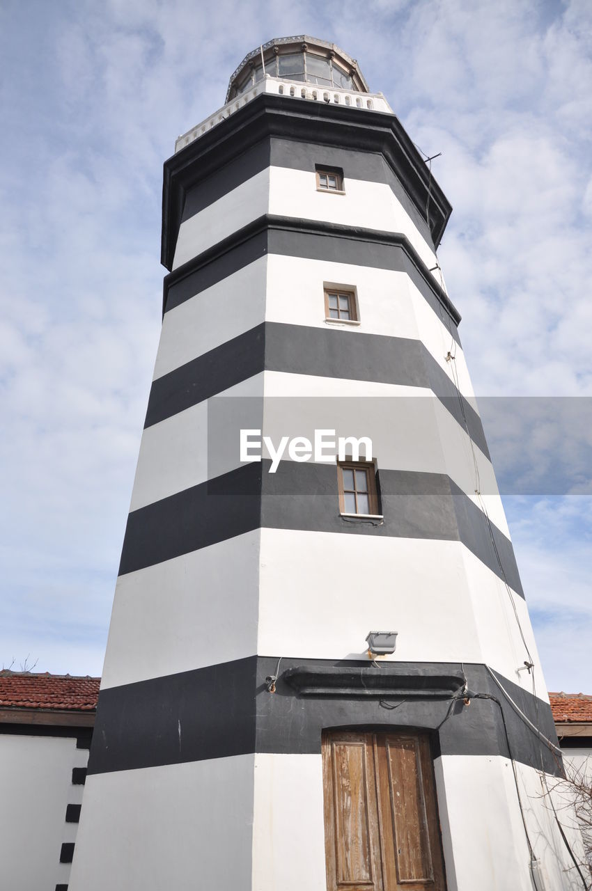 Low angle view of lighthouse against cloudy sky