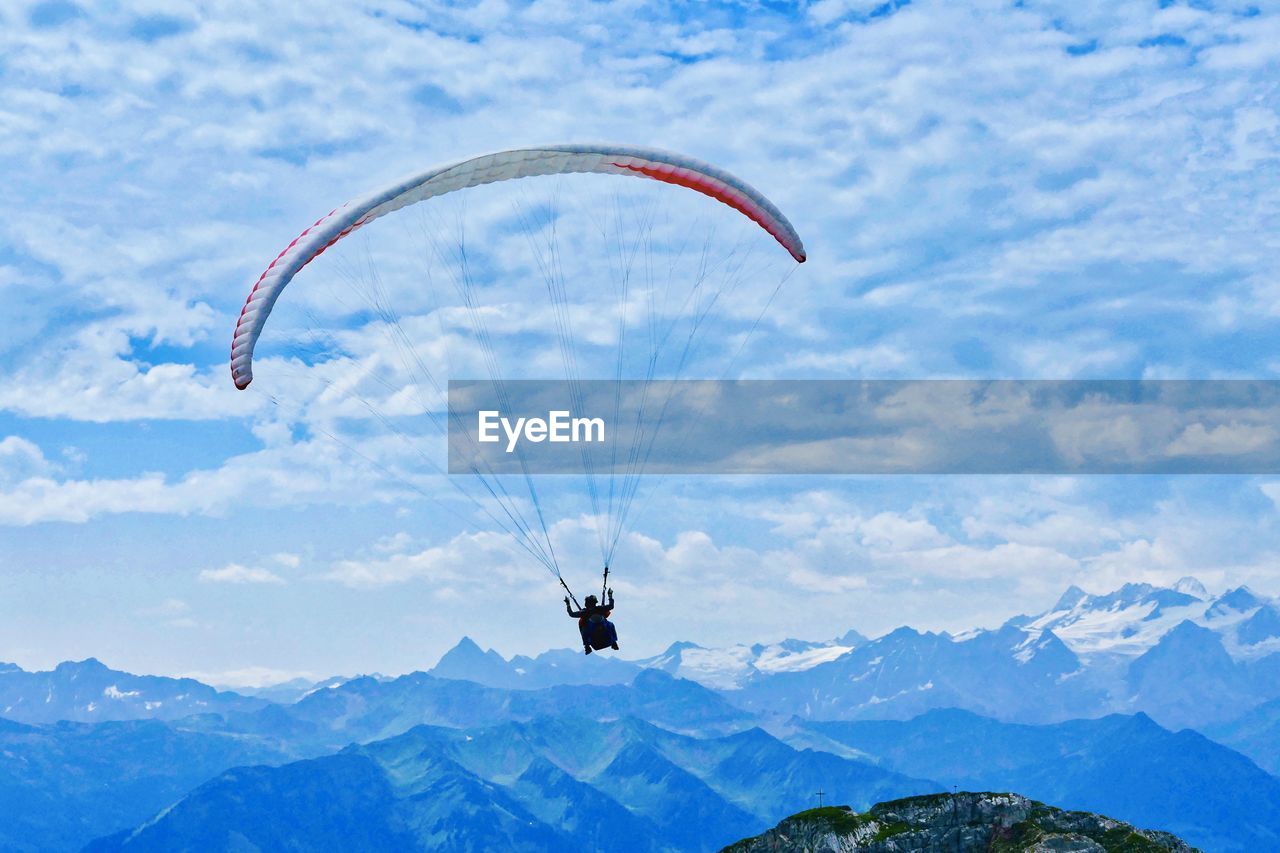 Person paragliding against sky