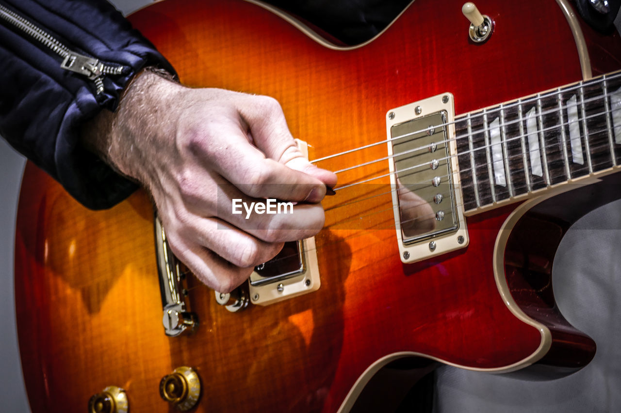 Cropped image of man playing electric guitar